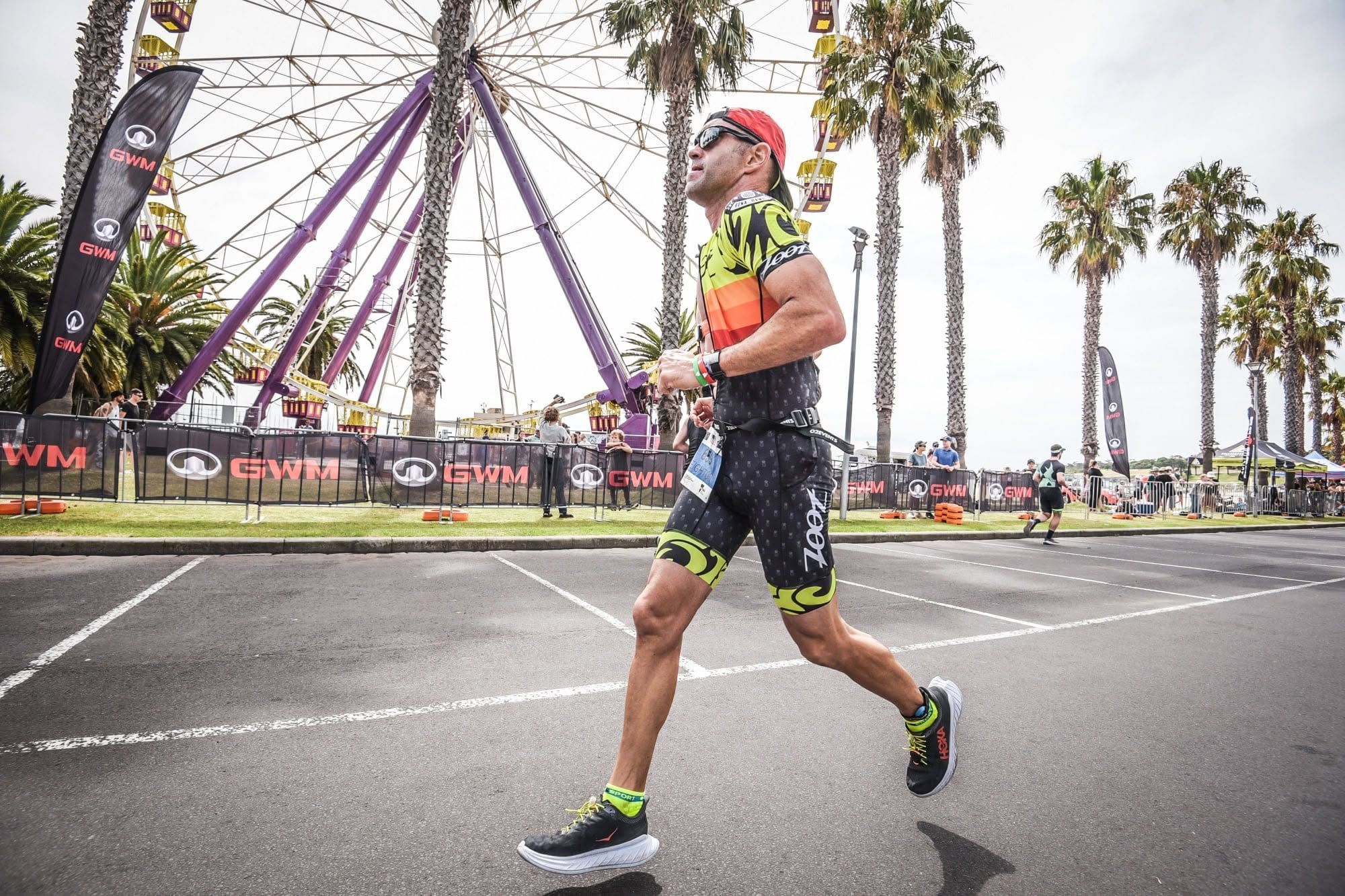 Leighton Wells running during a triathlon, with both feet off the road.